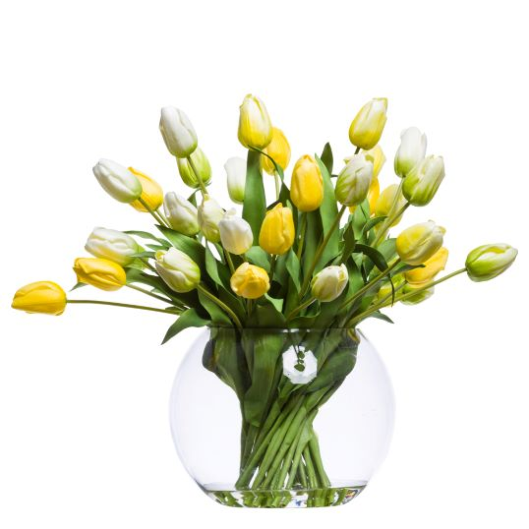 Yellow and white artificial tulips in a clear glass round vase arrangement