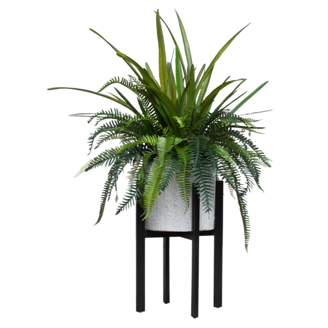 Artificial fern arrangement in white textured pot on black metal stand