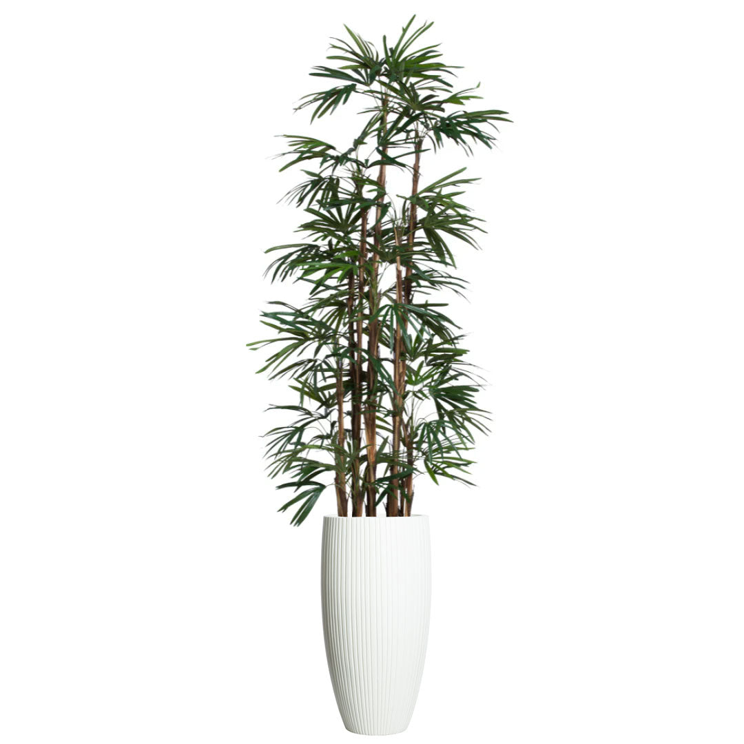 Artificial palm tree with slender green leaves in a tall white ribbed planter
