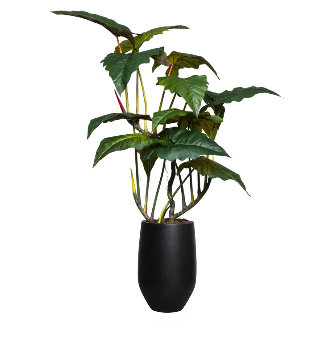Artificial philodendron plant with large green leaves in a tall black planter
