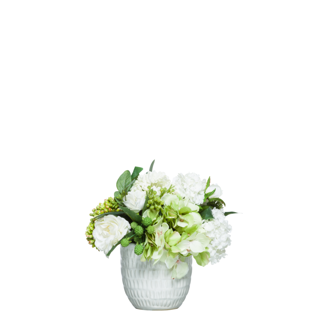 White rose and hydrangea silk flower arrangement in a textured white ceramic vase