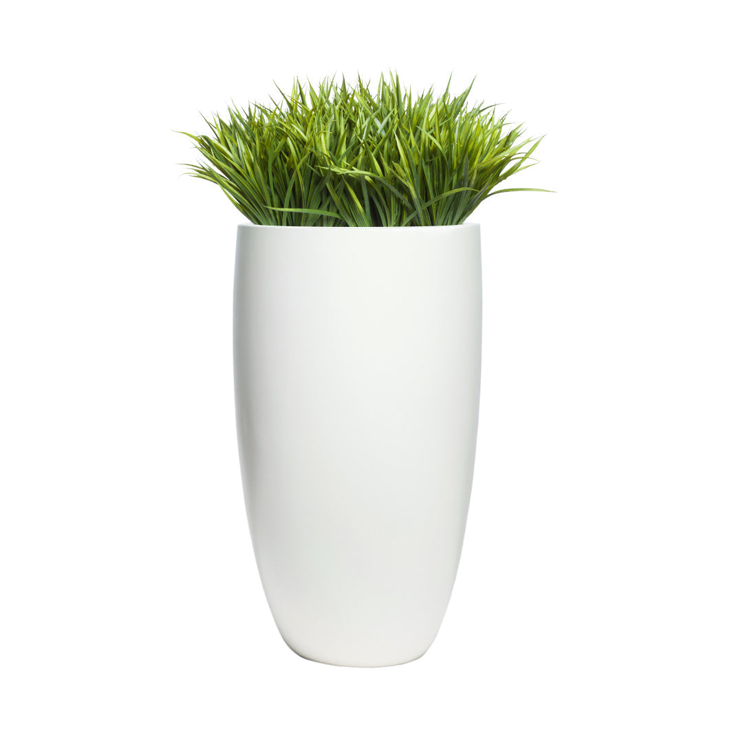 Artificial sword grass in a smooth tall white planter on white background