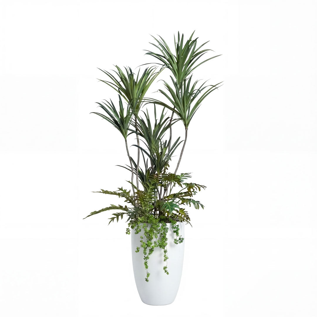 Artificial tropical plant with green foliage in a sleek white planter on a white background