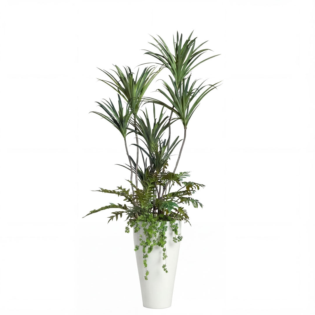 Artificial tropical plant arrangement in tall white vase with green foliage, white background