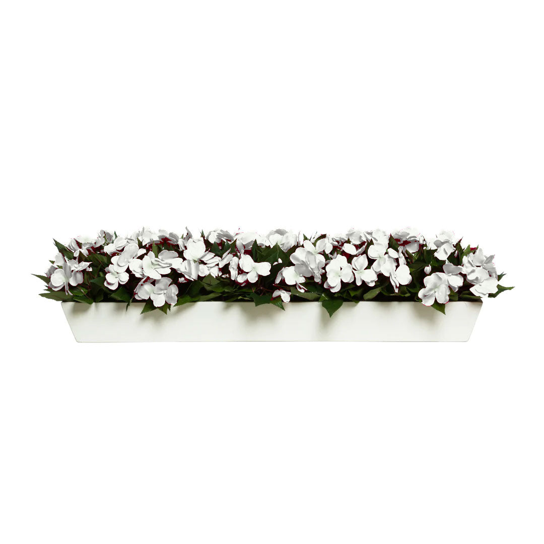 White artificial flowers with green leaves in a rectangular white planter against white background